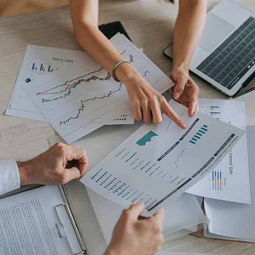 two people reviewing charts and graphs