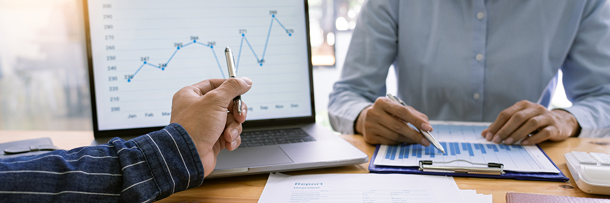 two people dressed in business casual reviewing graphs and charts 